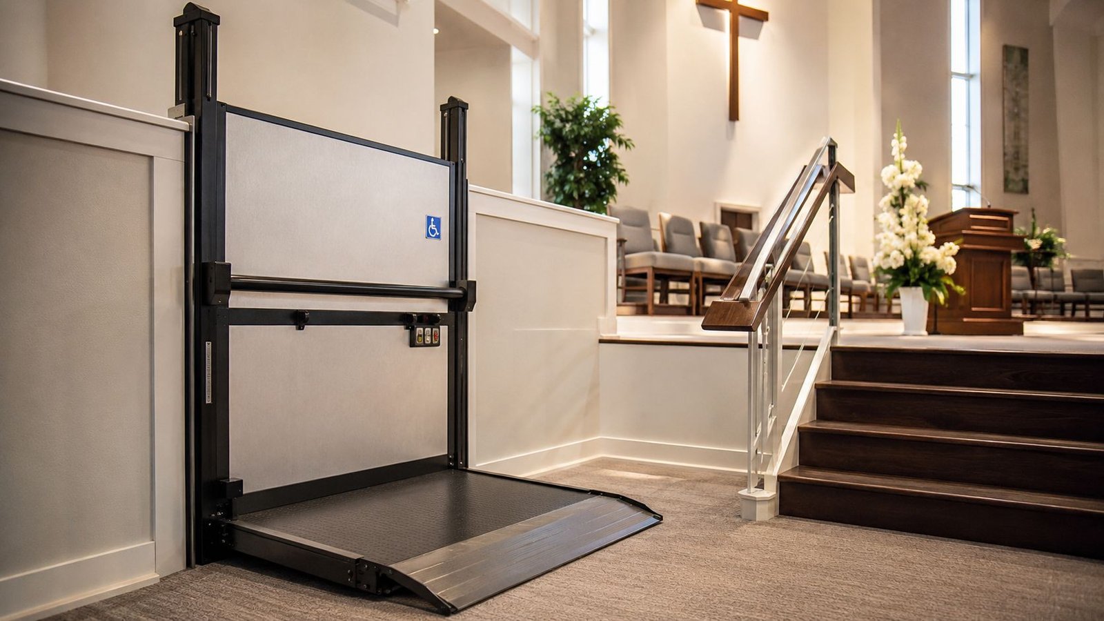 A wheelchair platform lift installed next to wooden stairs in a modern church sanctuary interior.